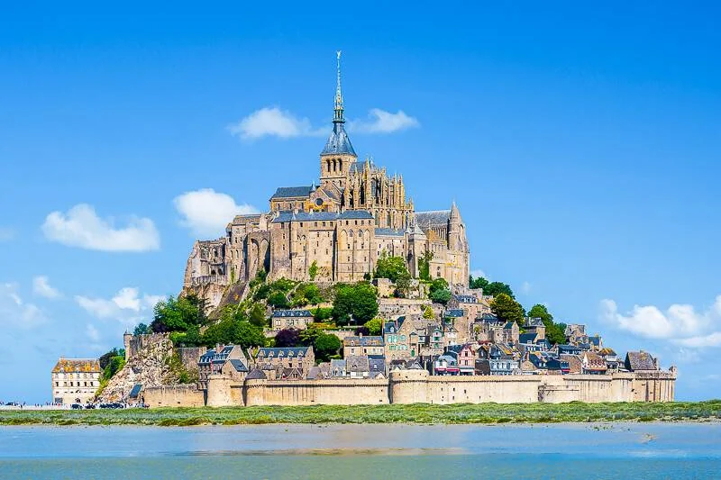 Day trips from Paris: Mont-Saint-Michel abbey rising from the bay under a blue sky