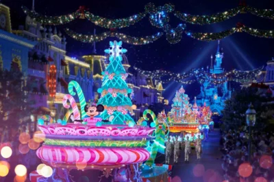Disneyland Paris Christmas parade with a lit candy-cane float and the castle in the background